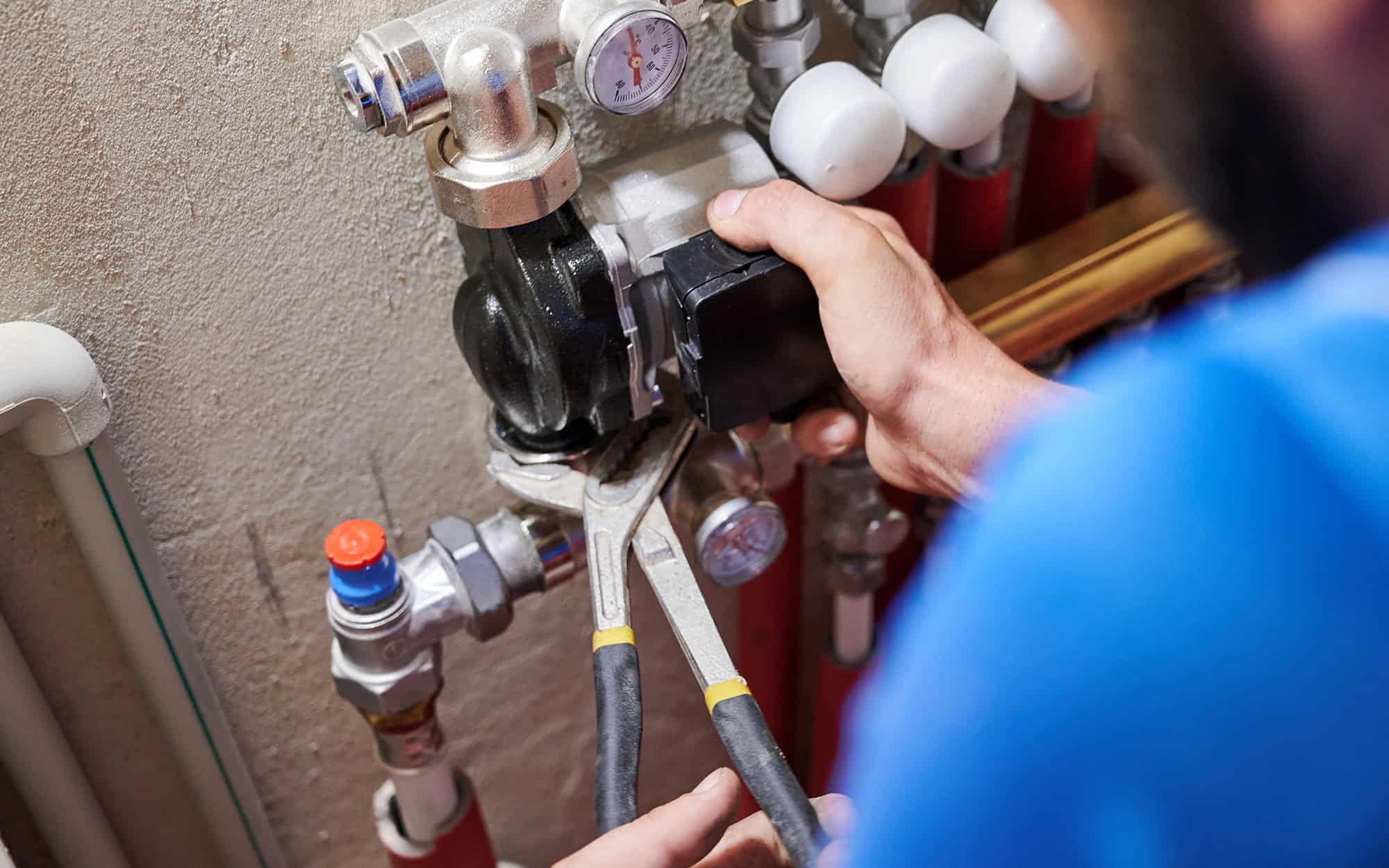 Plumber working on equipment with wrench